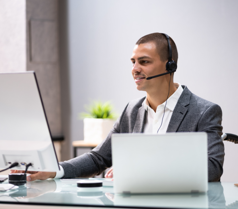 homme au telephone portant assistance avec deux ordinateurs
